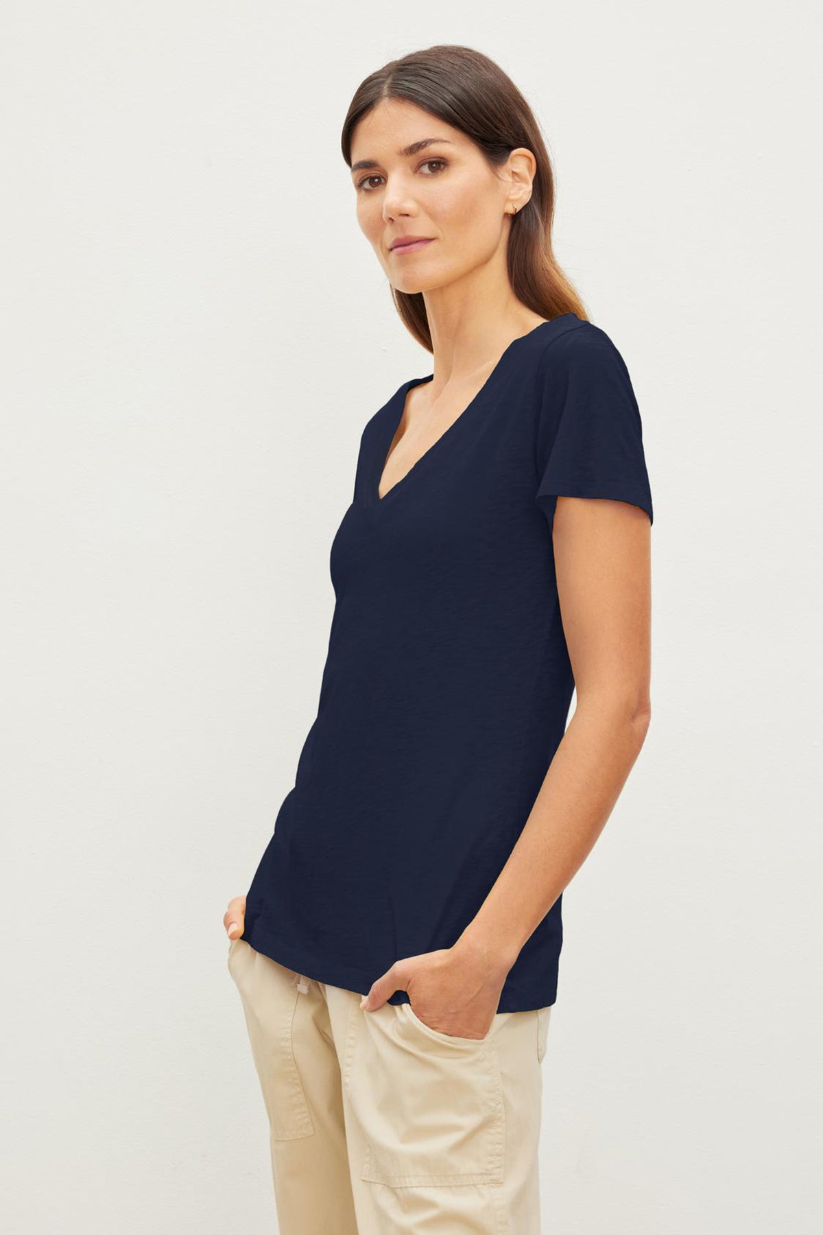   A woman in a navy LILITH COTTON SLUB V-NECK TEE, showcasing tomboy style by Velvet by Graham & Spencer. 