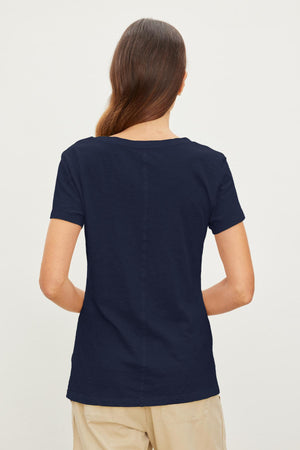 A woman with a LILITH COTTON SLUB V-NECK TEE, showcasing a tomboy style from Velvet by Graham & Spencer.