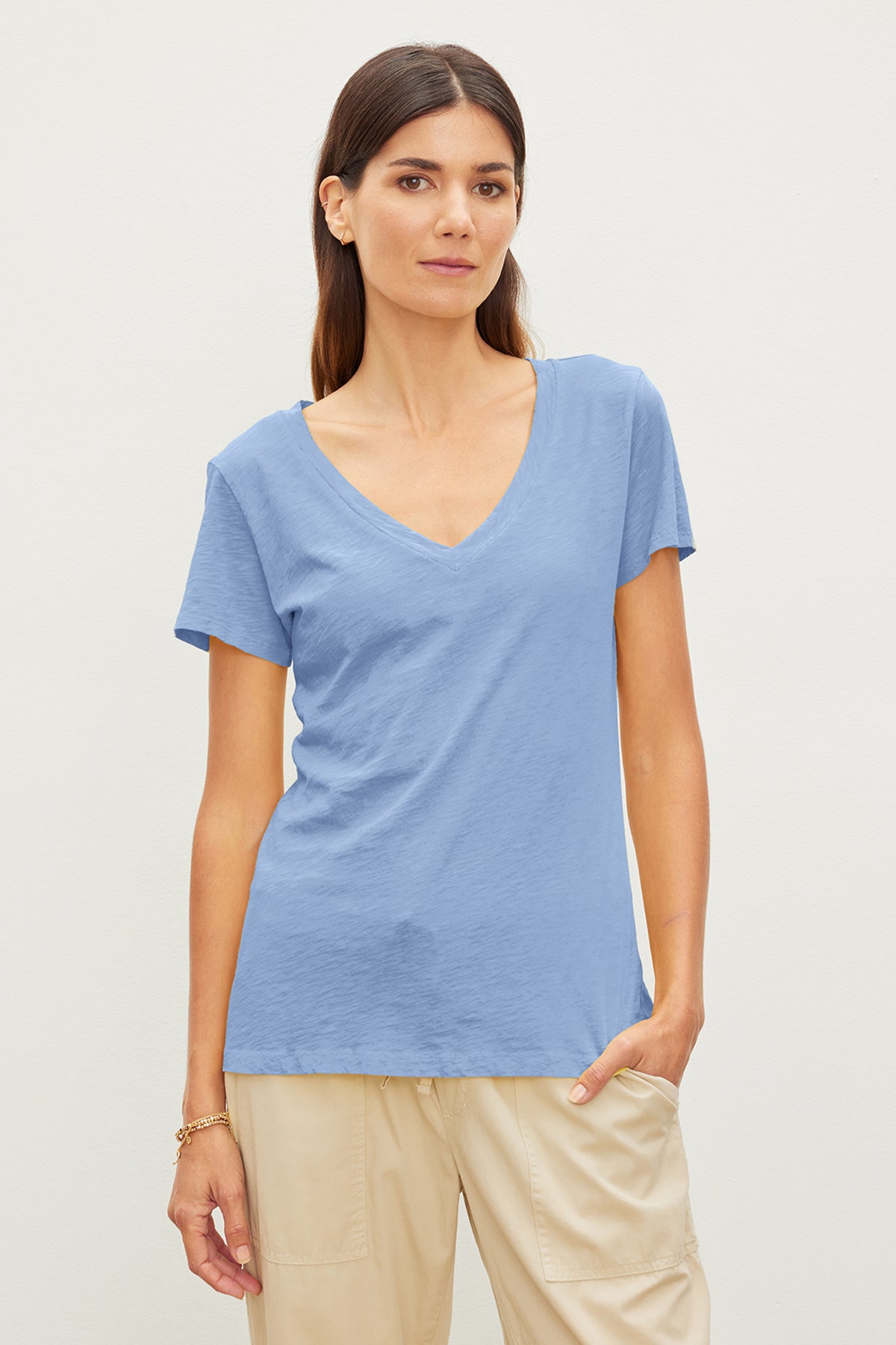   A woman with a tomboy style wearing a blue LILITH COTTON SLUB V-NECK TEE by Velvet by Graham & Spencer. 