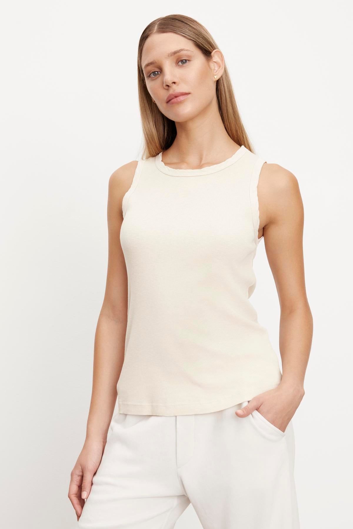   The fit model is wearing a MAXIE RIBBED TANK TOP from her closet and white pants. 