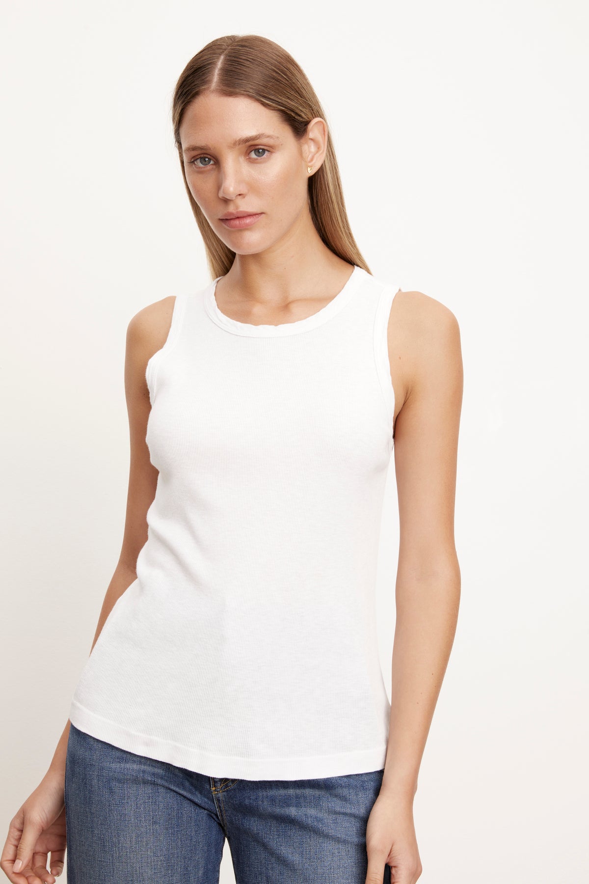 a woman wearing a Velvet by Graham & Spencer white MAXIE RIBBED TANK TOP and jeans.-26514178801857