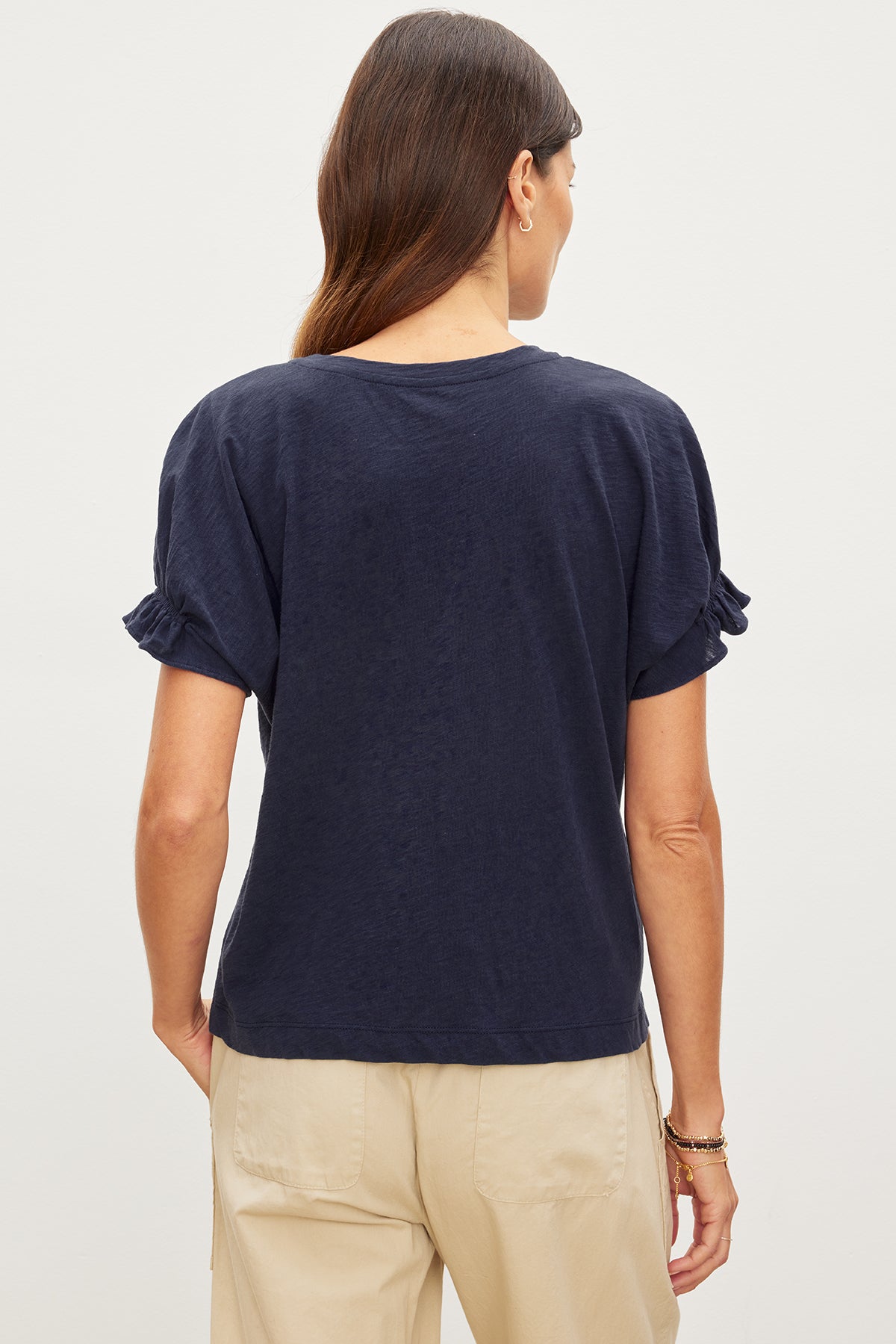   The back view of a woman wearing a MIMI CREW NECK TEE, a wardrobe essential with its cotton slub fabric and crew neckline, by Velvet by Graham & Spencer. 