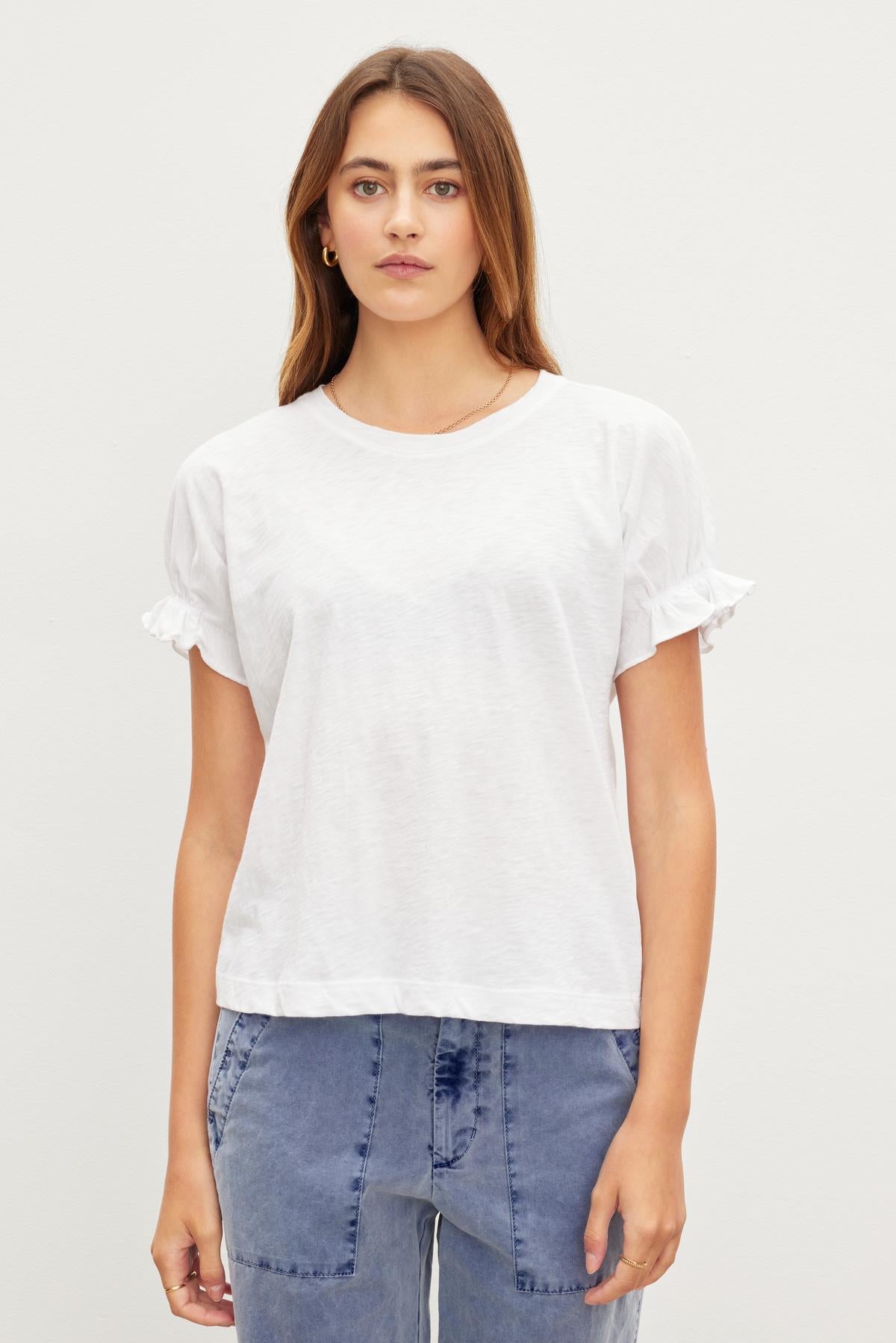   A woman in a white cotton MIMI CREW NECK TEE, a wardrobe essential by Velvet by Graham & Spencer with a crew neckline. 
