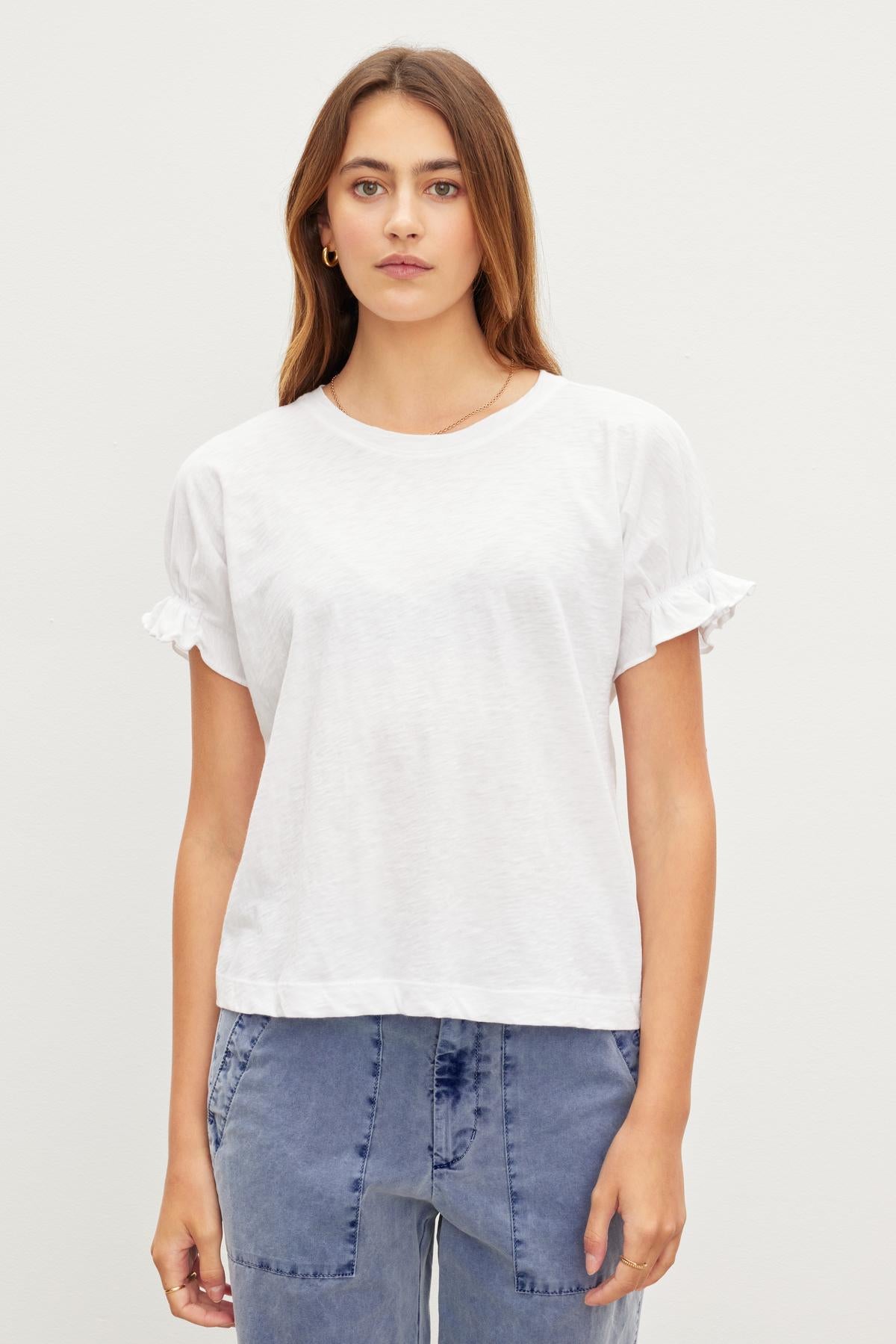 A woman in a white cotton MIMI CREW NECK TEE, a wardrobe essential by Velvet by Graham & Spencer with a crew neckline.-35982818508993