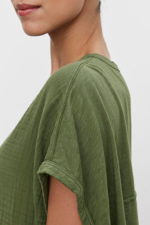 Close-up of a woman wearing a Velvet by Graham & Spencer CAROLINE COCOON TOP, focusing on the shoulder seam and fabric detail.