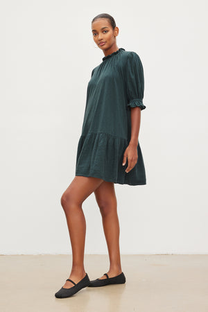 The model is wearing a Velvet by Graham & Spencer Dillon Tiered Dress with ruffled sleeves.