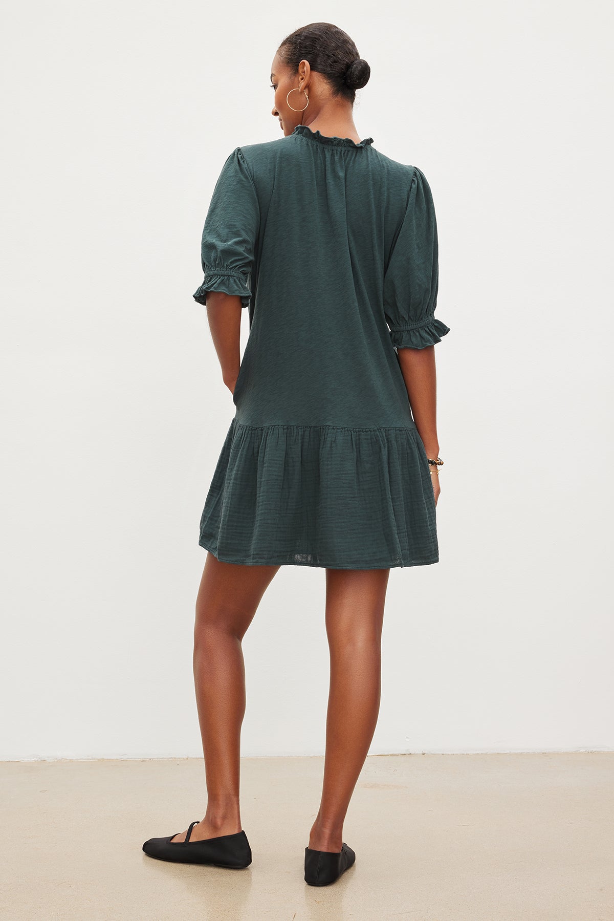  The back view of a woman wearing the Velvet by Graham & Spencer DILLON TIERED DRESS with ruffled sleeves. 