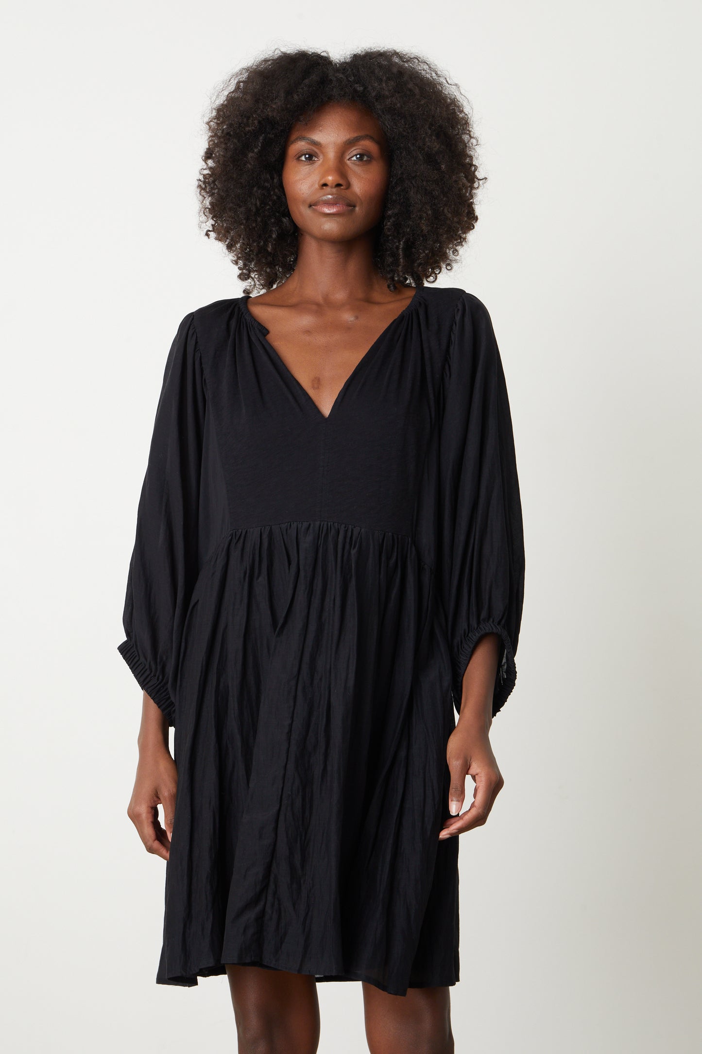 The ERIN SHIRRED WAIST DRESS by Velvet by Graham & Spencer in black has a v-neck and a ruffled hem.-26577354490049
