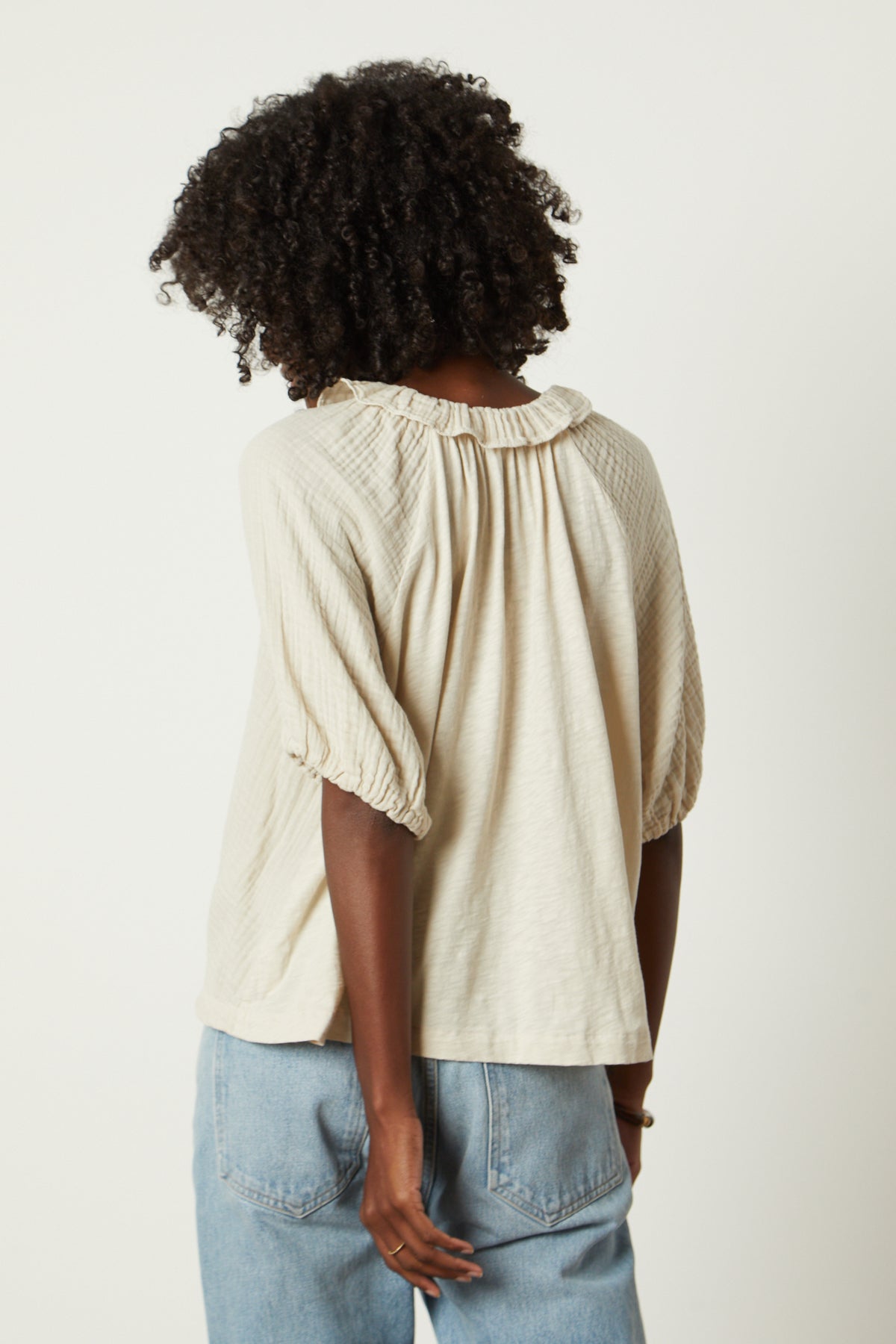   The back view of a woman wearing a Velvet by Graham & Spencer Ilene Puff Sleeve Top. 