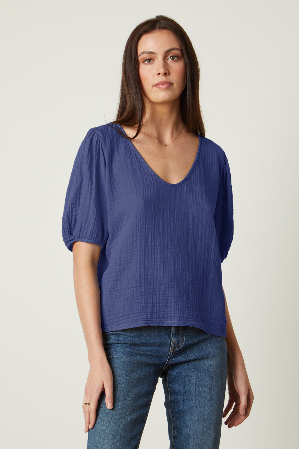   a woman wearing jeans and a LOUISA PUFF SLEEVE TOP by Velvet by Graham & Spencer. 