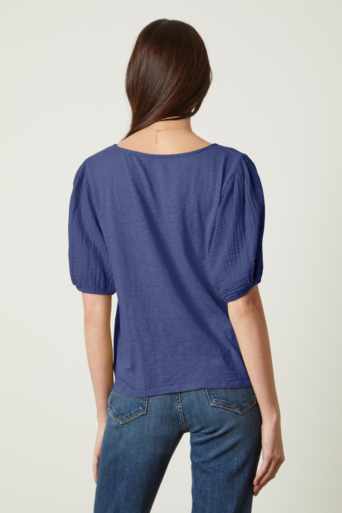 the back view of a woman wearing a Velvet by Graham & Spencer LOUISA PUFF SLEEVE TOP.-26572649234625
