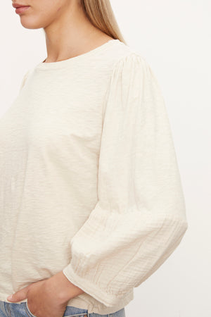 the model is wearing a Velvet by Graham & Spencer Mariel Puff Sleeve Tee.