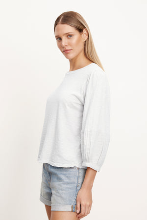The model is wearing a MARIEL PUFF SLEEVE TEE by Velvet by Graham & Spencer.