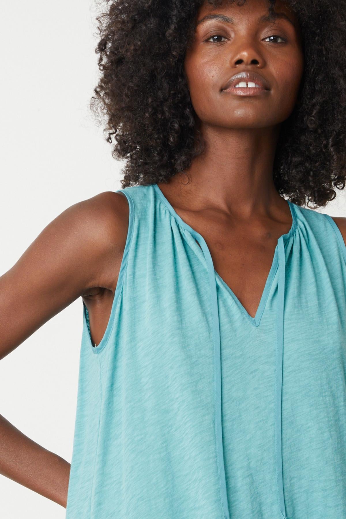 A black woman wearing a Velvet by Graham & Spencer turquoise tank top.-35205246484673