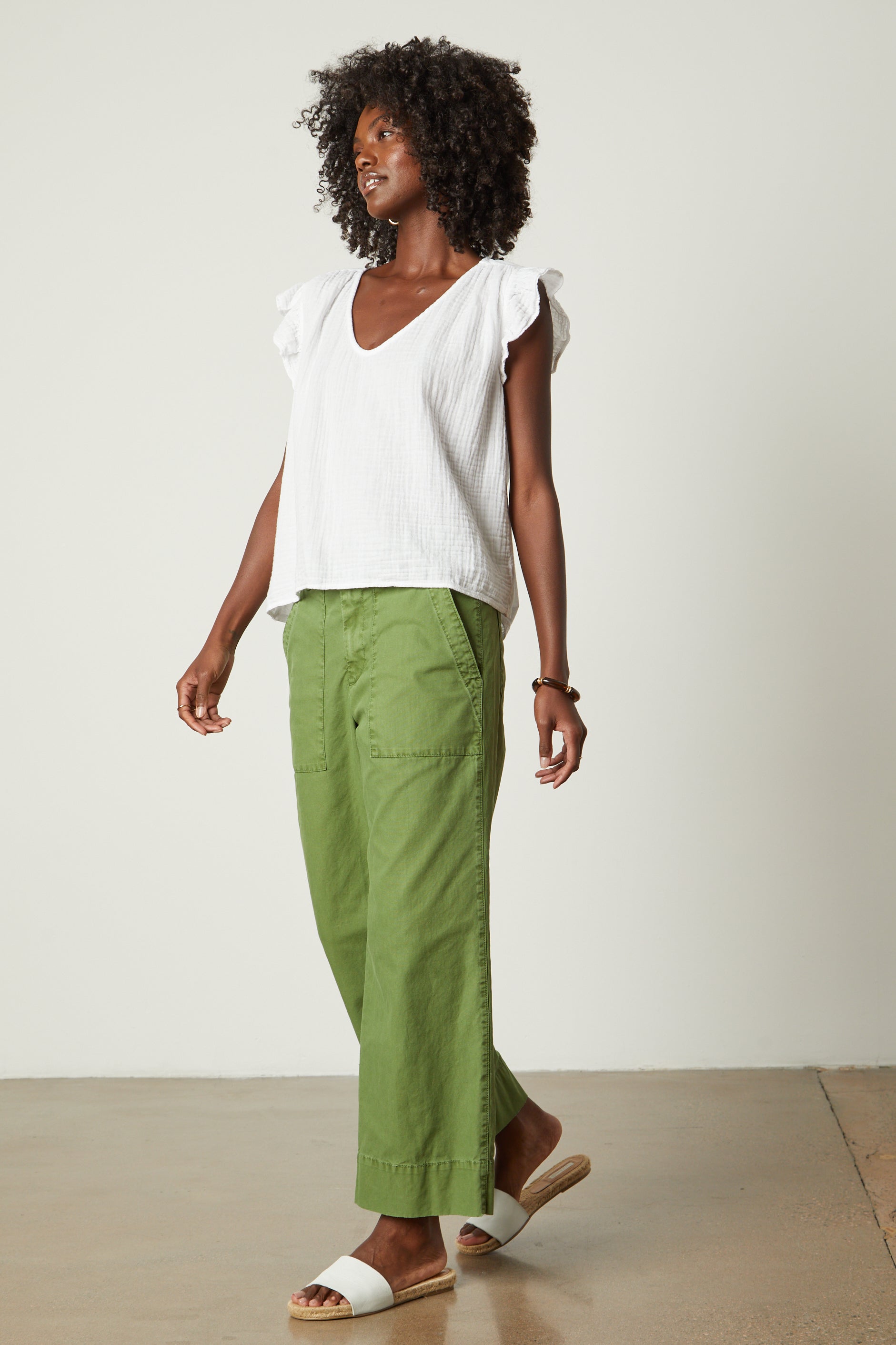   a woman wearing green pants and a Velvet by Graham & Spencer REMI RUFFLE SLEEVE TOP. 