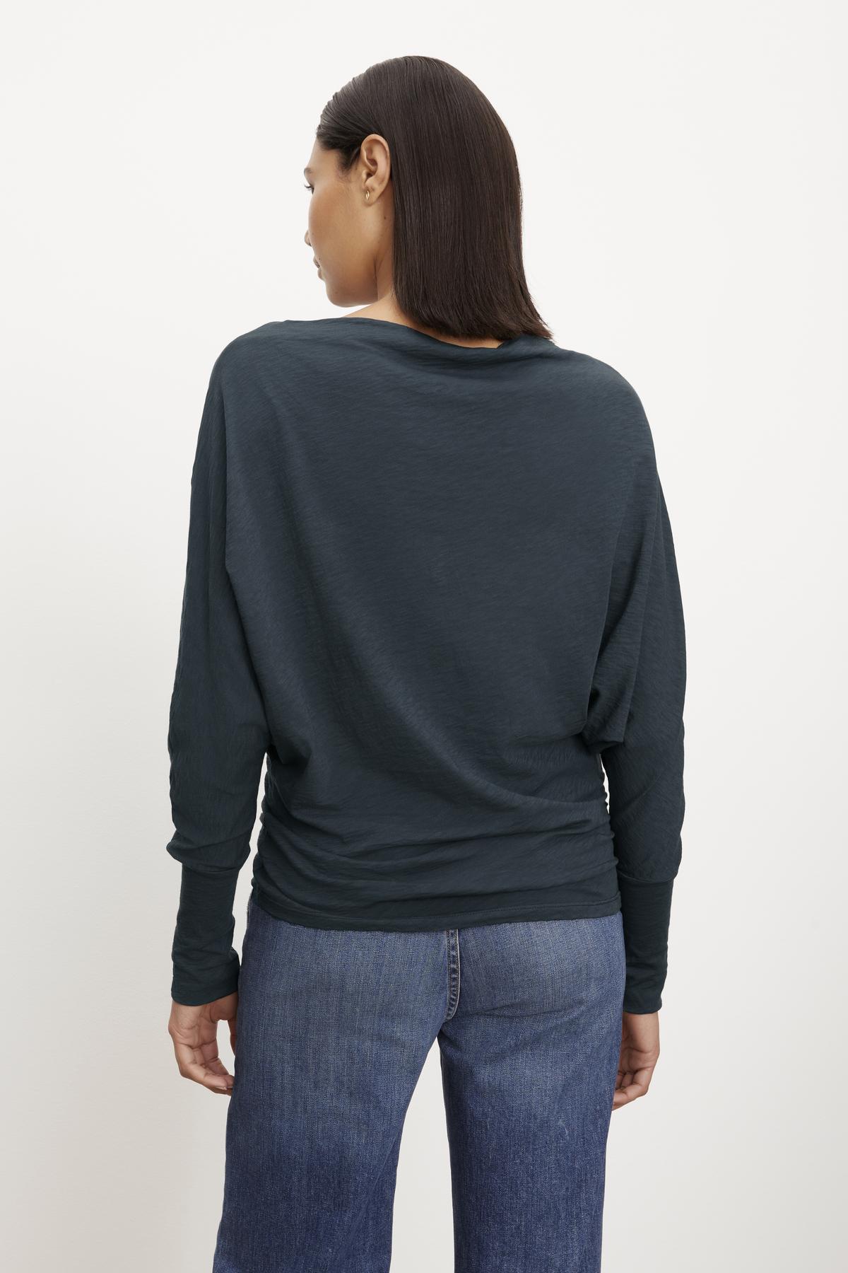   The view of a woman wearing the NOVALEE DOLMAN TEE by Velvet by Graham & Spencer and jeans. 
