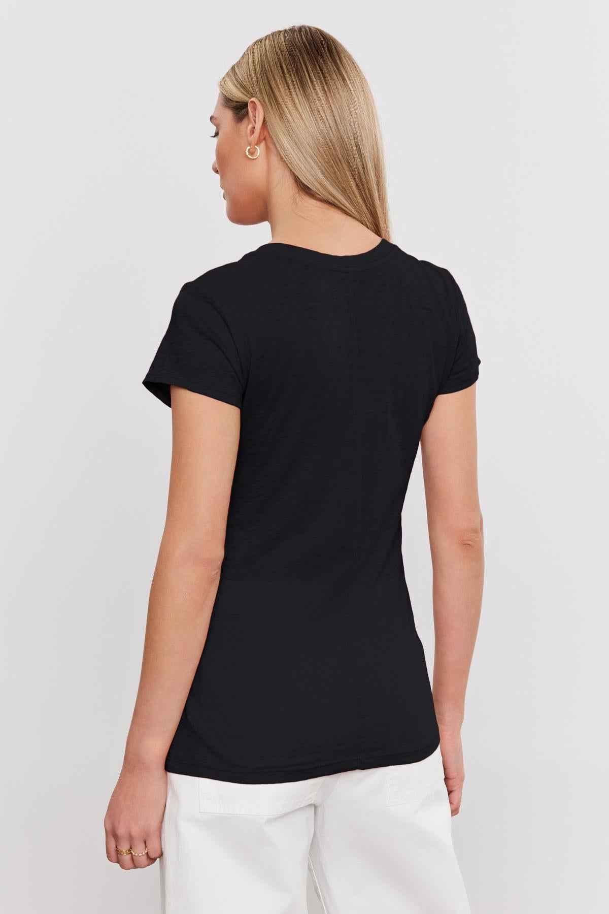   The woman is wearing a black ODELIA COTTON SLUB CREW NECK TEE by Velvet by Graham & Spencer. 