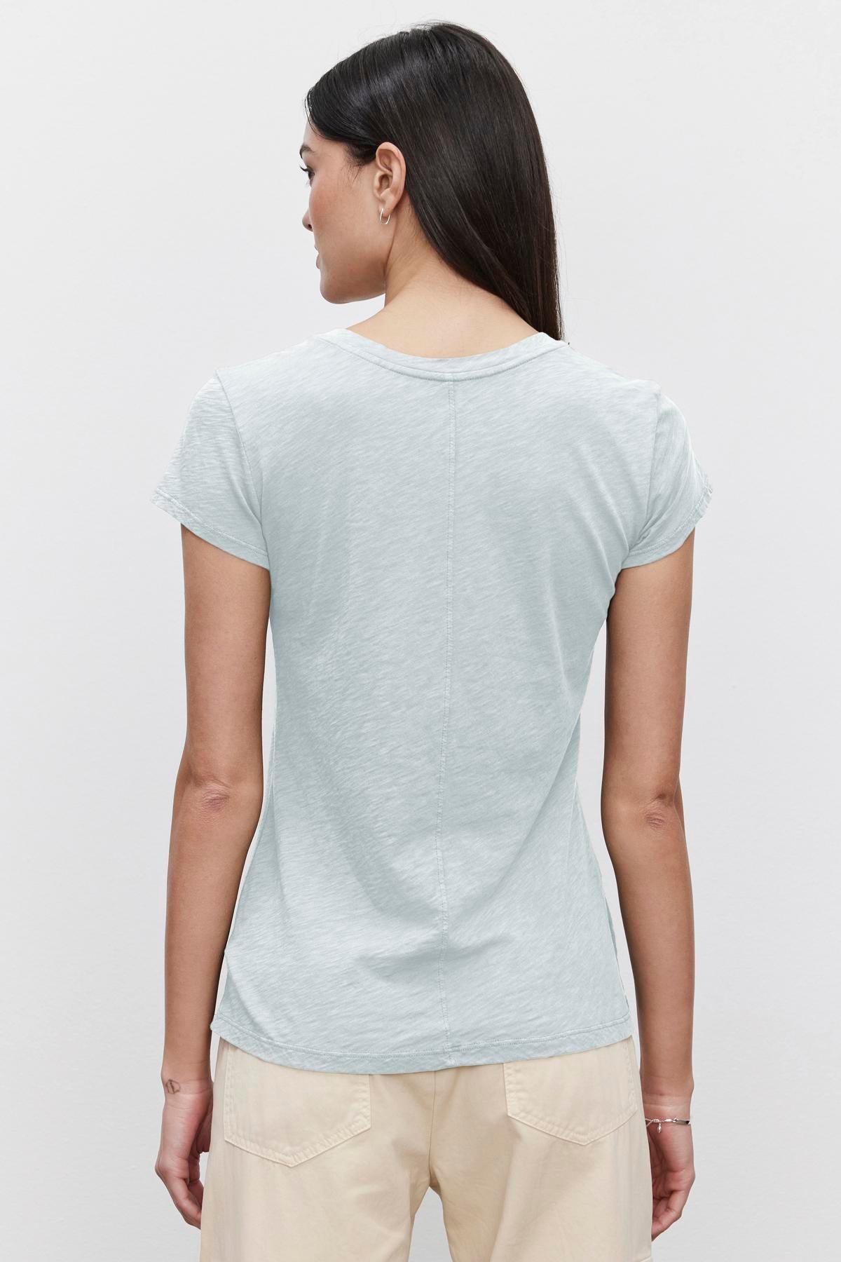 Woman viewed from behind wearing a light blue, Velvet by Graham & Spencer ODELIA COTTON SLUB CREW NECK TEE and beige pants.-36653433028801