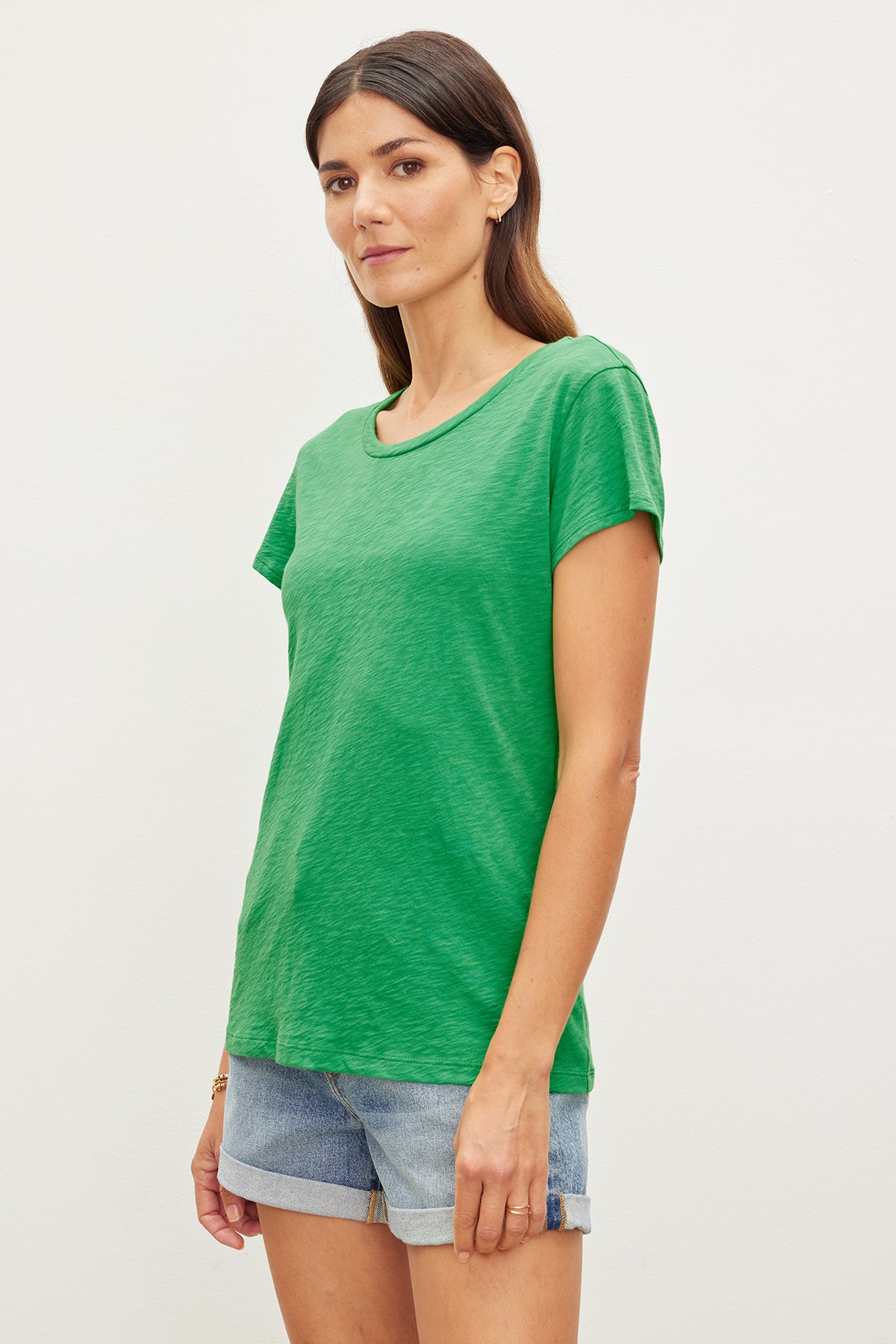   A woman wearing a green ODELIA COTTON SLUB CREW NECK TEE and shorts. (Brand: Velvet by Graham & Spencer) 