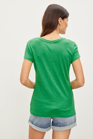 The back view of a woman wearing a Velvet by Graham & Spencer ODELIA COTTON SLUB CREW NECK TEE.