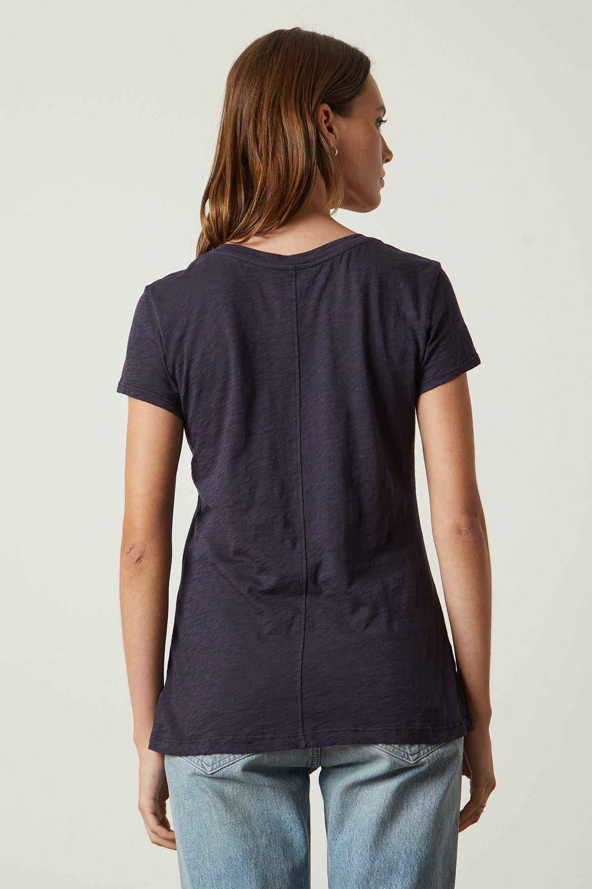 the back view of a woman wearing jeans and a Navy ODELIA COTTON SLUB CREW NECK TEE by Velvet by Graham & Spencer.-26631431487681