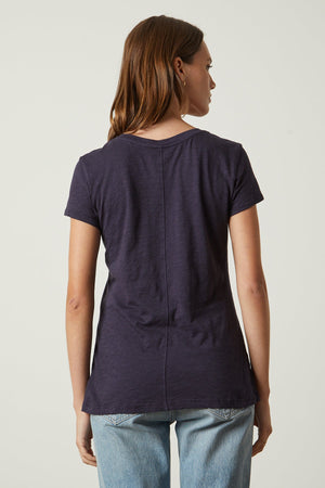 the back view of a woman wearing jeans and a Navy ODELIA COTTON SLUB CREW NECK TEE by Velvet by Graham & Spencer.
