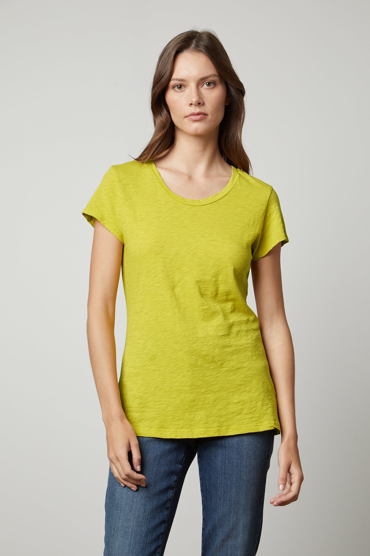 A woman wearing a yellow Velvet by Graham & Spencer ODELIA COTTON SLUB CREW NECK TEE and jeans.-35206800834753