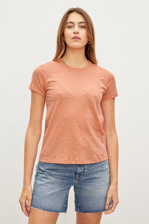 A woman in a retro vibe pink SIERRA CREW NECK TEE made from cotton slub, by Velvet by Graham & Spencer.