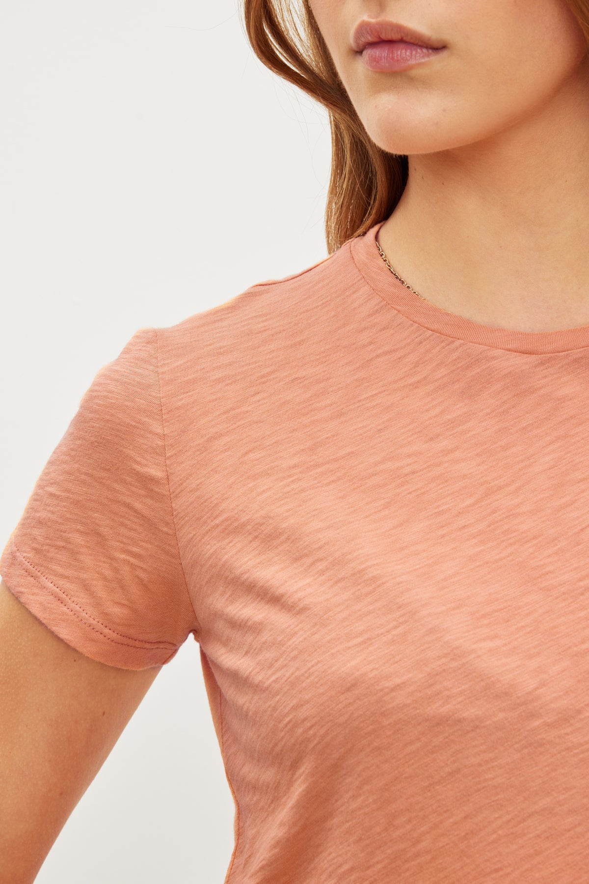 A close up of a woman's neck with a retro vibe featuring the SIERRA CREW NECK TEE by Velvet by Graham & Spencer.-35982935064769