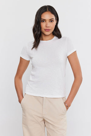 The model is wearing a white SIERRA CREW NECK TEE by Velvet by Graham & Spencer.