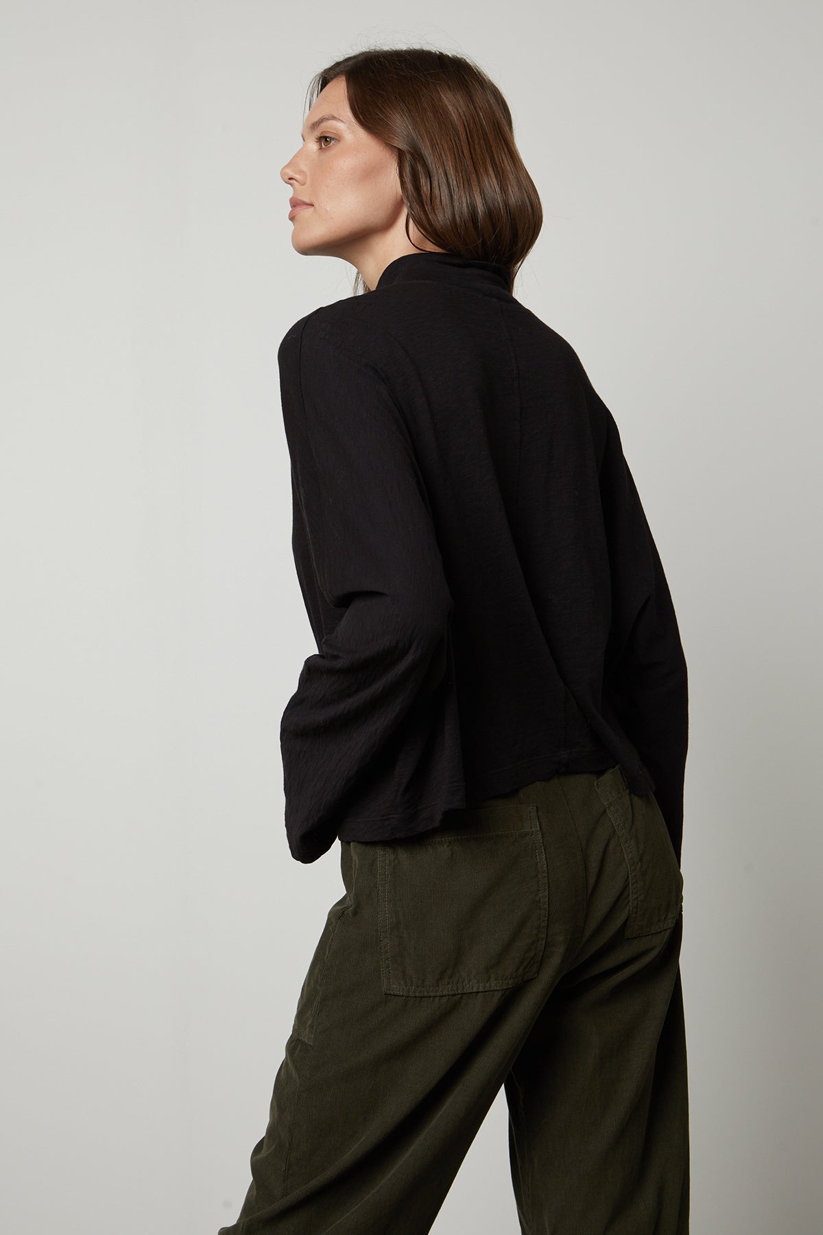 The back view of a person wearing Velvet by Graham & Spencer olive pants and a STACEY MOCK NECK TEE.-26895469379777