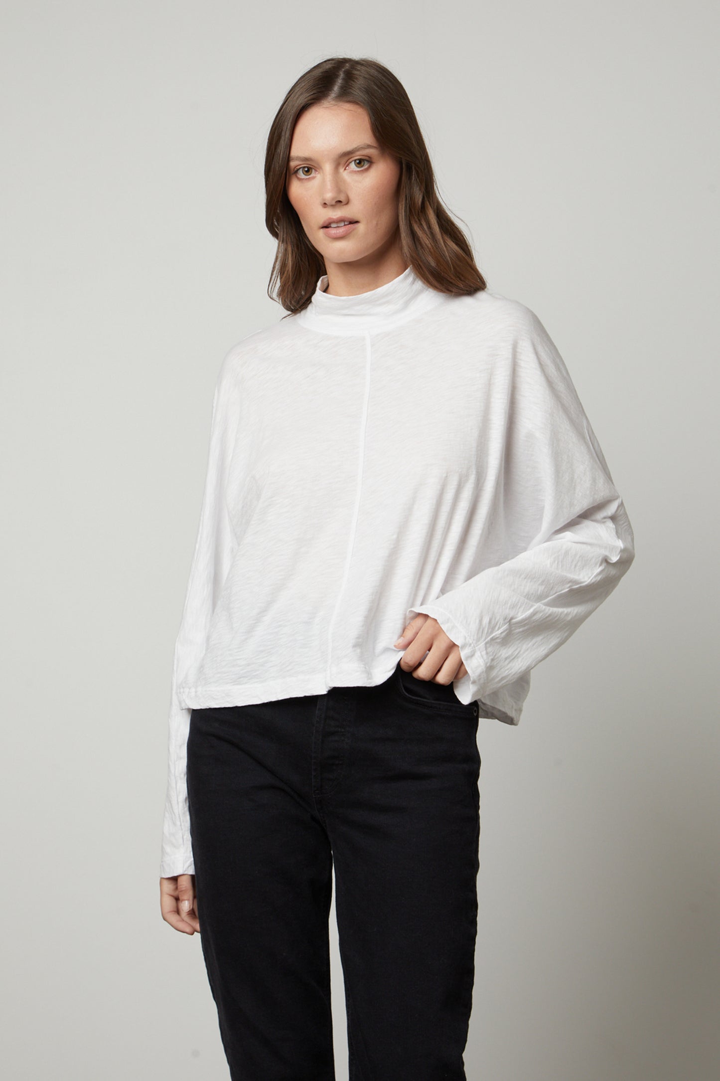 The model is wearing a white STACEY MOCK NECK TEE by Velvet by Graham & Spencer and black jeans.-26883549561025