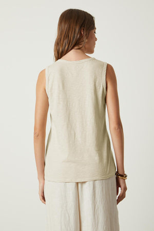 The back view of a woman wearing a Velvet by Graham & Spencer TAURUS COTTON SLUB TANK in beige.
