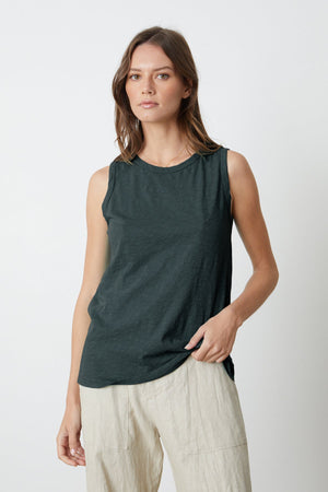 a woman wearing a Velvet by Graham & Spencer TAURUS COTTON SLUB TANK in dark green and beige pants.
