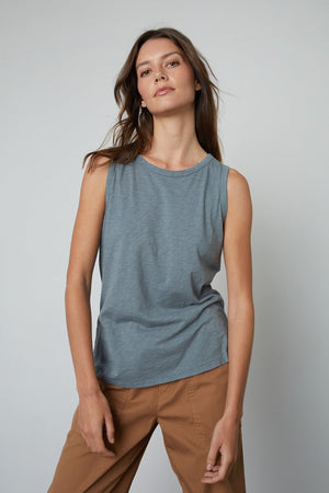 The model is wearing a Velvet by Graham & Spencer TAURUS COTTON SLUB TANK and brown pants.