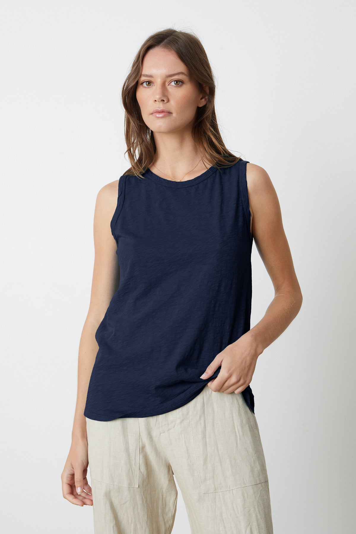   a woman wearing a Velvet by Graham & Spencer TAURUS COTTON SLUB TANK in navy and beige pants. 
