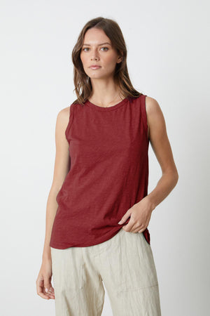 A woman in a burgundy TAURUS COTTON SLUB TANK by Velvet by Graham & Spencer and beige pants, styled in a crew-neck shirt.