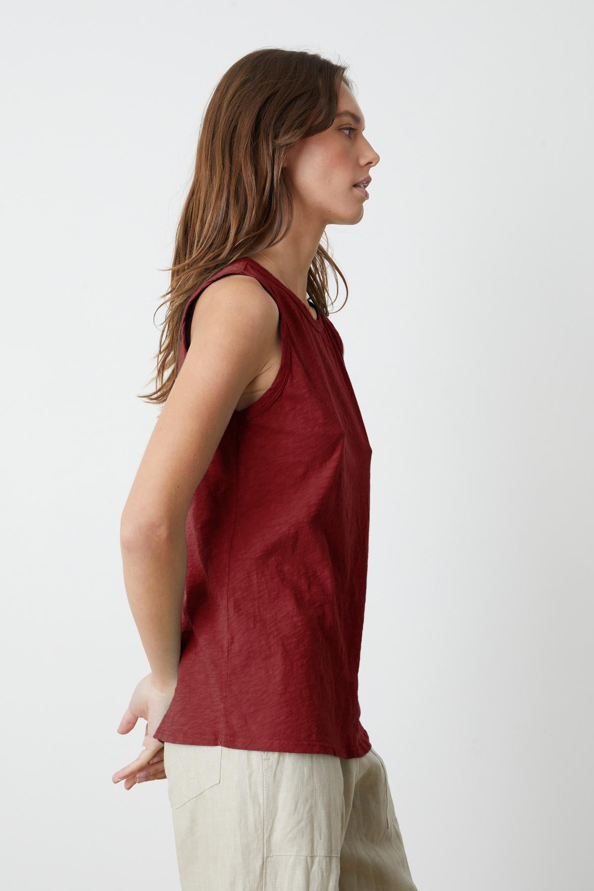 A woman wearing a red crew-neck top and Velvet by Graham & Spencer TAURUS COTTON SLUB TANK.-35783162200257