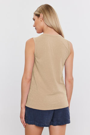 Woman wearing a beige TAURUS COTTON SLUB TANK and denim shorts, seen from the back, standing against a white background. (Brand Name: Velvet by Graham & Spencer)
