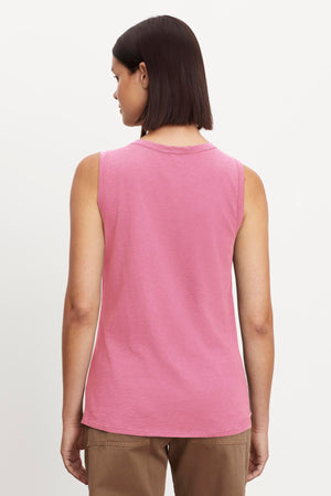 A person with short dark hair is seen from behind, wearing a sleeveless TAURUS TANK TOP made of textured cotton slub by Velvet by Graham & Spencer and brown pants.