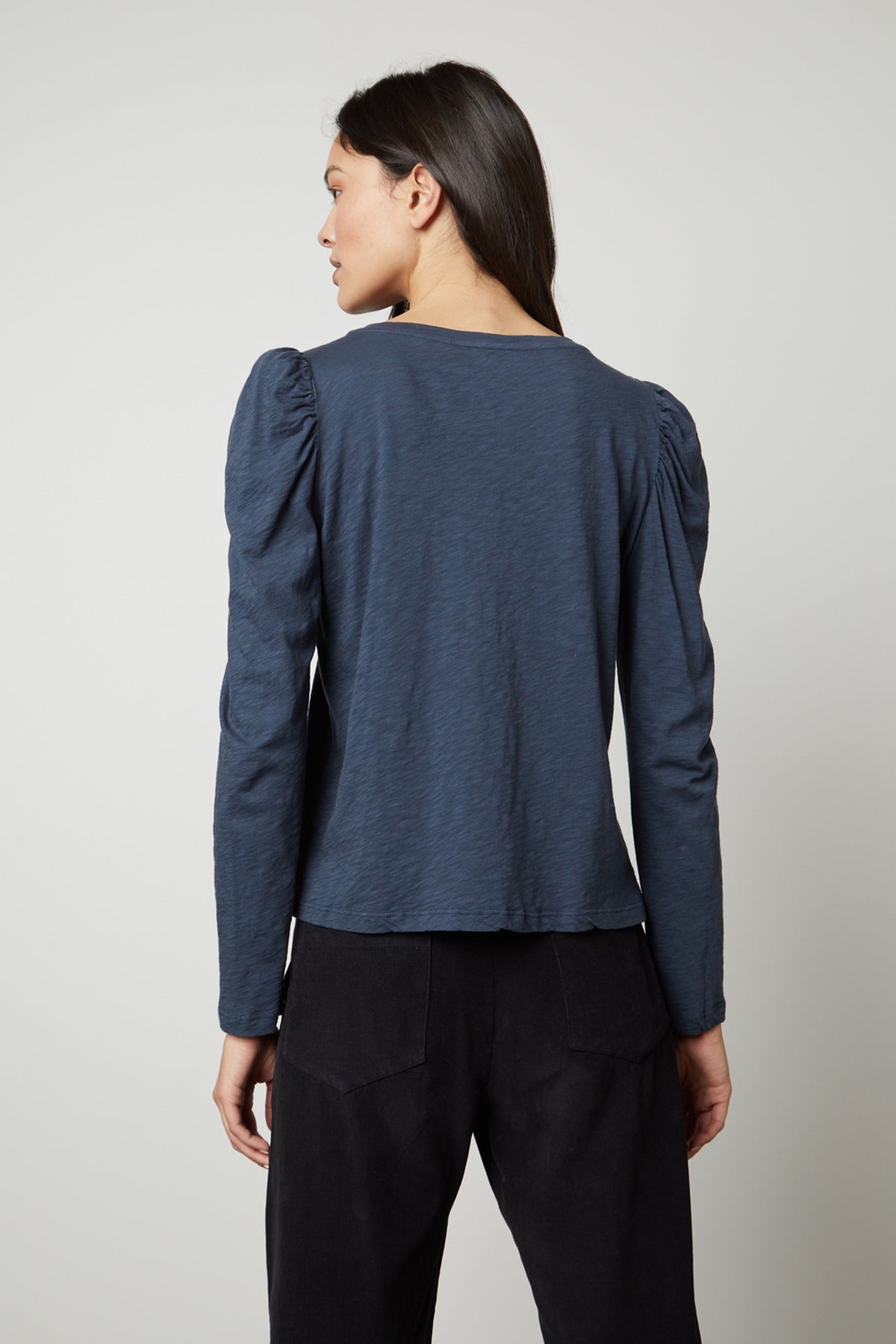 The back view of a woman wearing a Velvet by Graham & Spencer TORA CREW NECK TEE.-26872376819905
