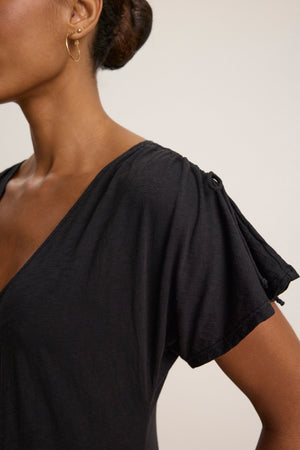 A woman in the VERONICA DRESS by Velvet by Graham & Spencer, shown from the shoulders up in side profile with small hoop earrings, showcases the versatile v-neckline and gathered shoulder details of this stylish dress.