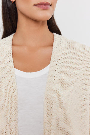Close-up of a woman wearing a Velvet by Graham & Spencer HOLLIE CARDIGAN over a white top, focusing on the neckline area.