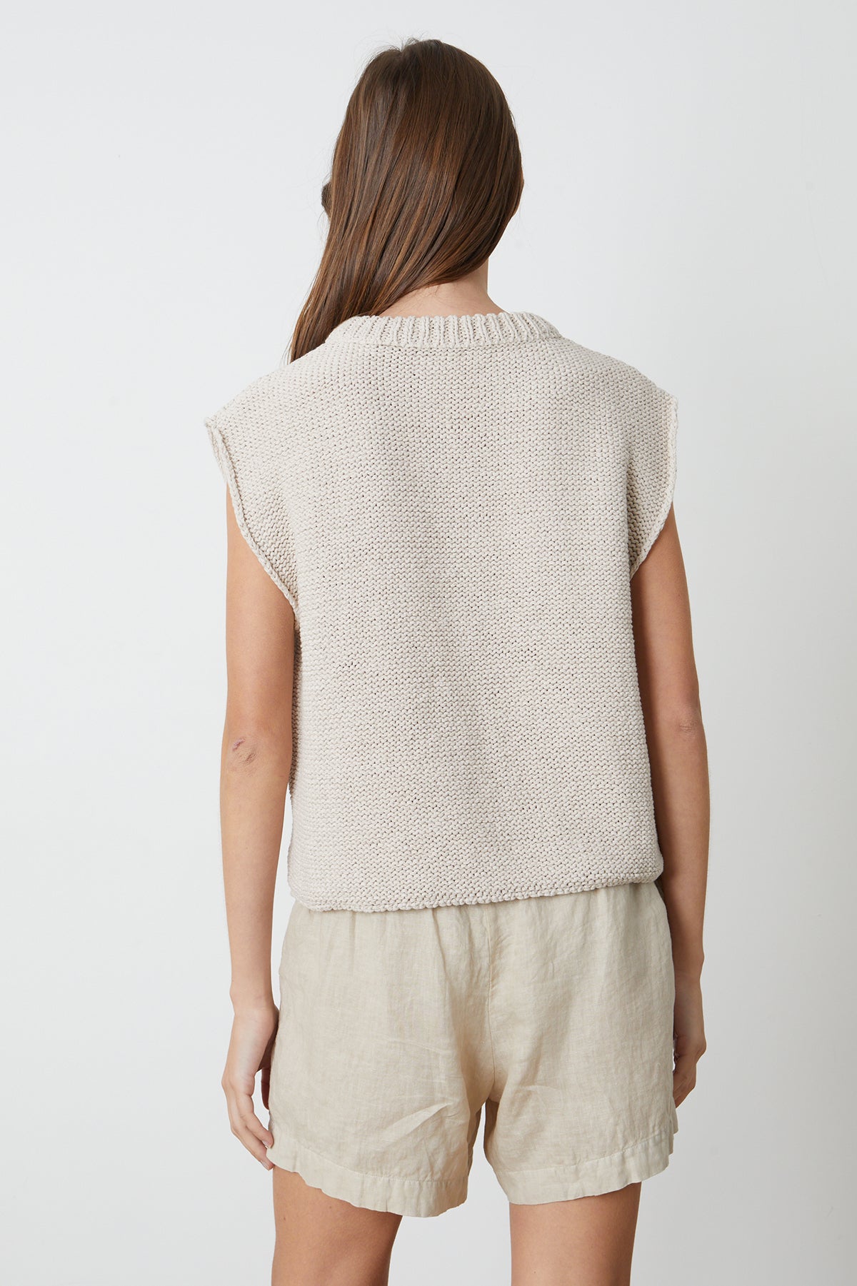 the back view of a woman wearing a Velvet by Graham & Spencer SAGE CREW NECK SWEATER and shorts.-26342770737345