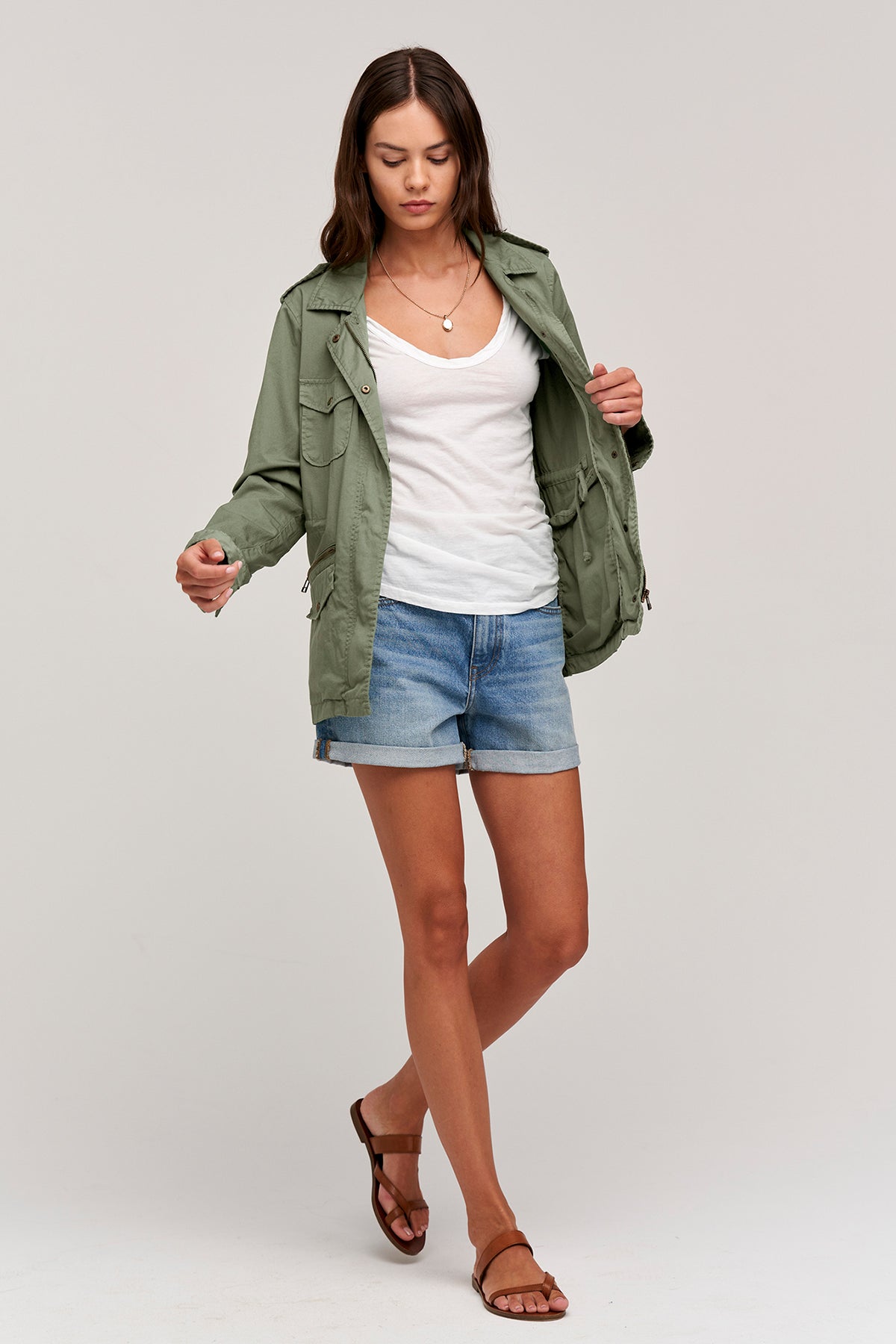  A woman wearing a RUBY LIGHT-WEIGHT ARMY JACKET by Velvet by Graham & Spencer and shorts. 