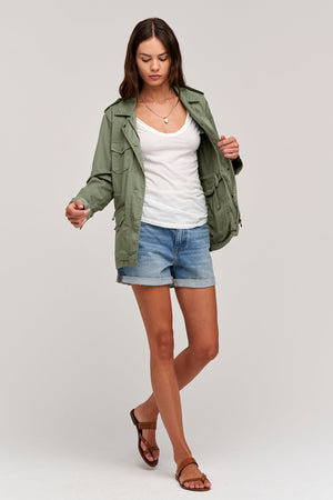 A woman wearing a RUBY LIGHT-WEIGHT ARMY JACKET by Velvet by Graham & Spencer and shorts.