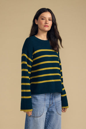 Front view of relaxed-fit dark green LUCIA cotton cashmere striped sweater with yellow stripes against beige background