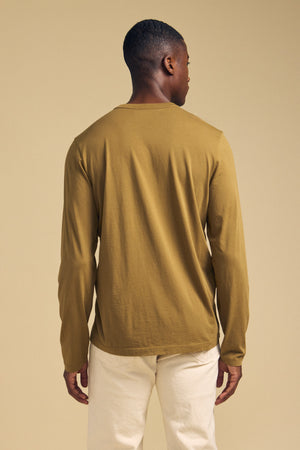 Back view of a person wearing a ROWLAND TEE long-sleeve Pima jersey crewneck shirt and light-colored pants.