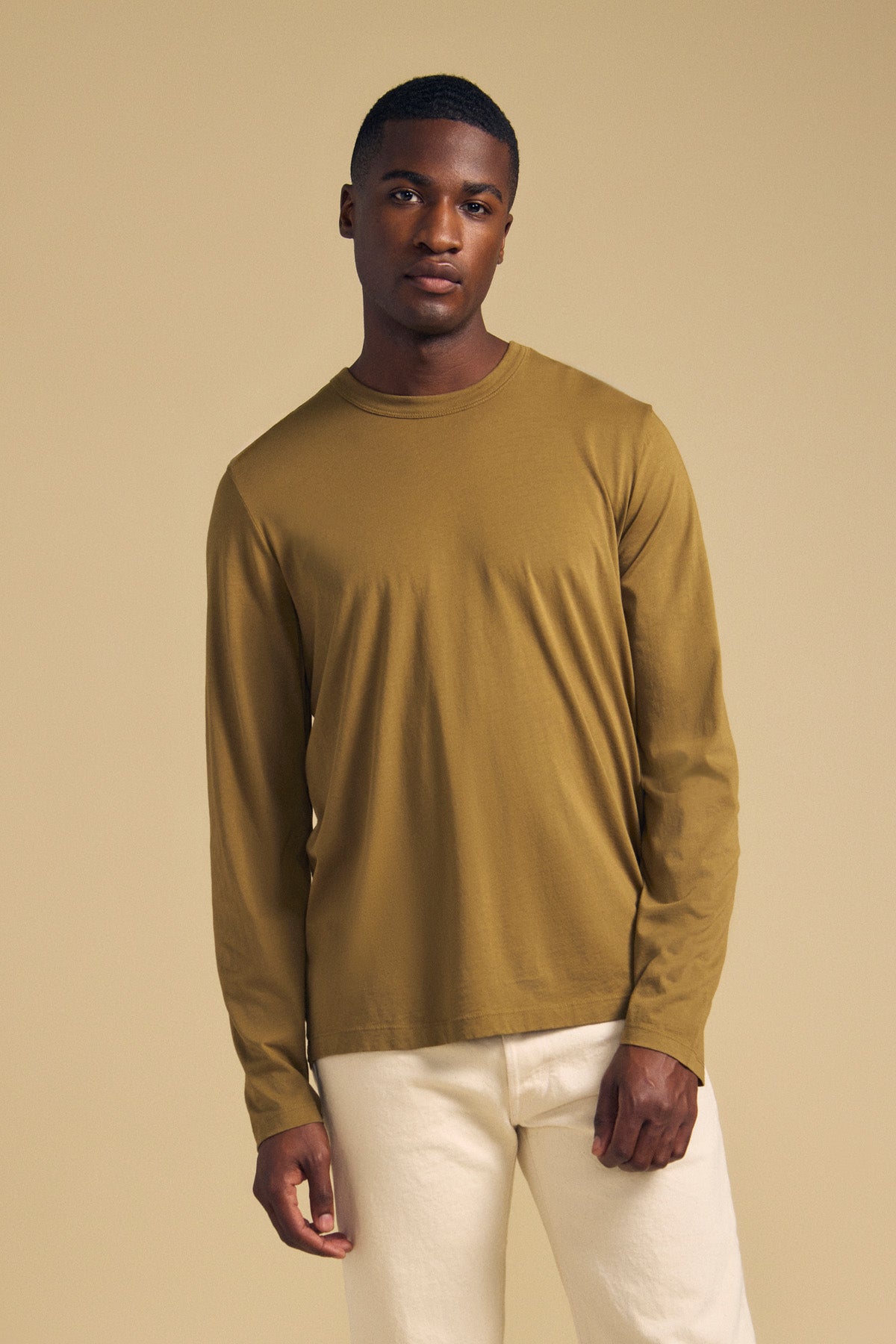 A man wearing an olive green ROWLAND TEE long-sleeve Pima jersey crew-neck t-shirt and white pants.-46288297099457