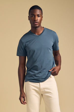 A man wearing a Velvet by Graham & Spencer SAMSEN TEE Pima jersey V-neck T-shirt and light-colored pants.